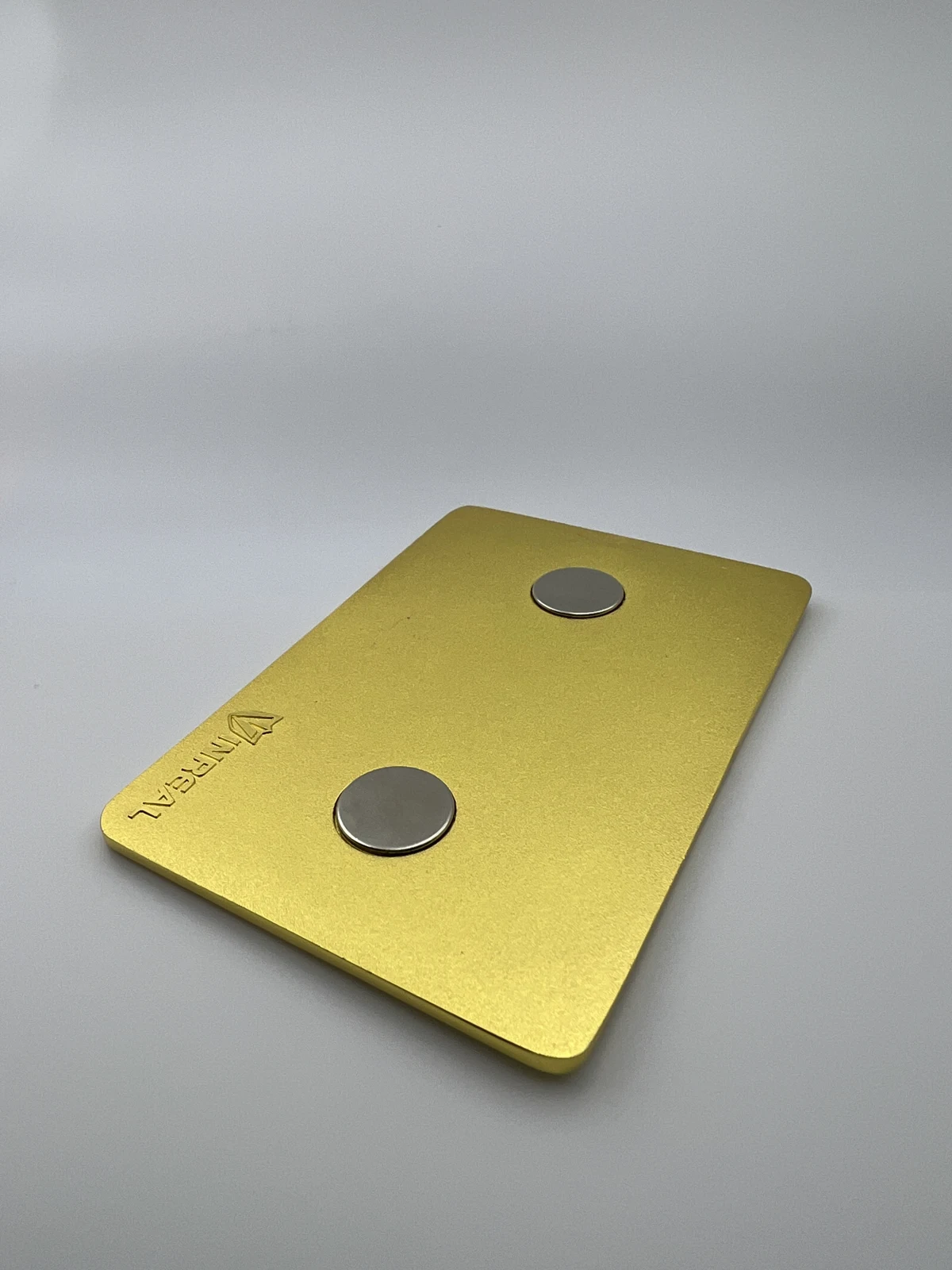 Rear of a metal magnet showing two round magnets and the VINREAL mark